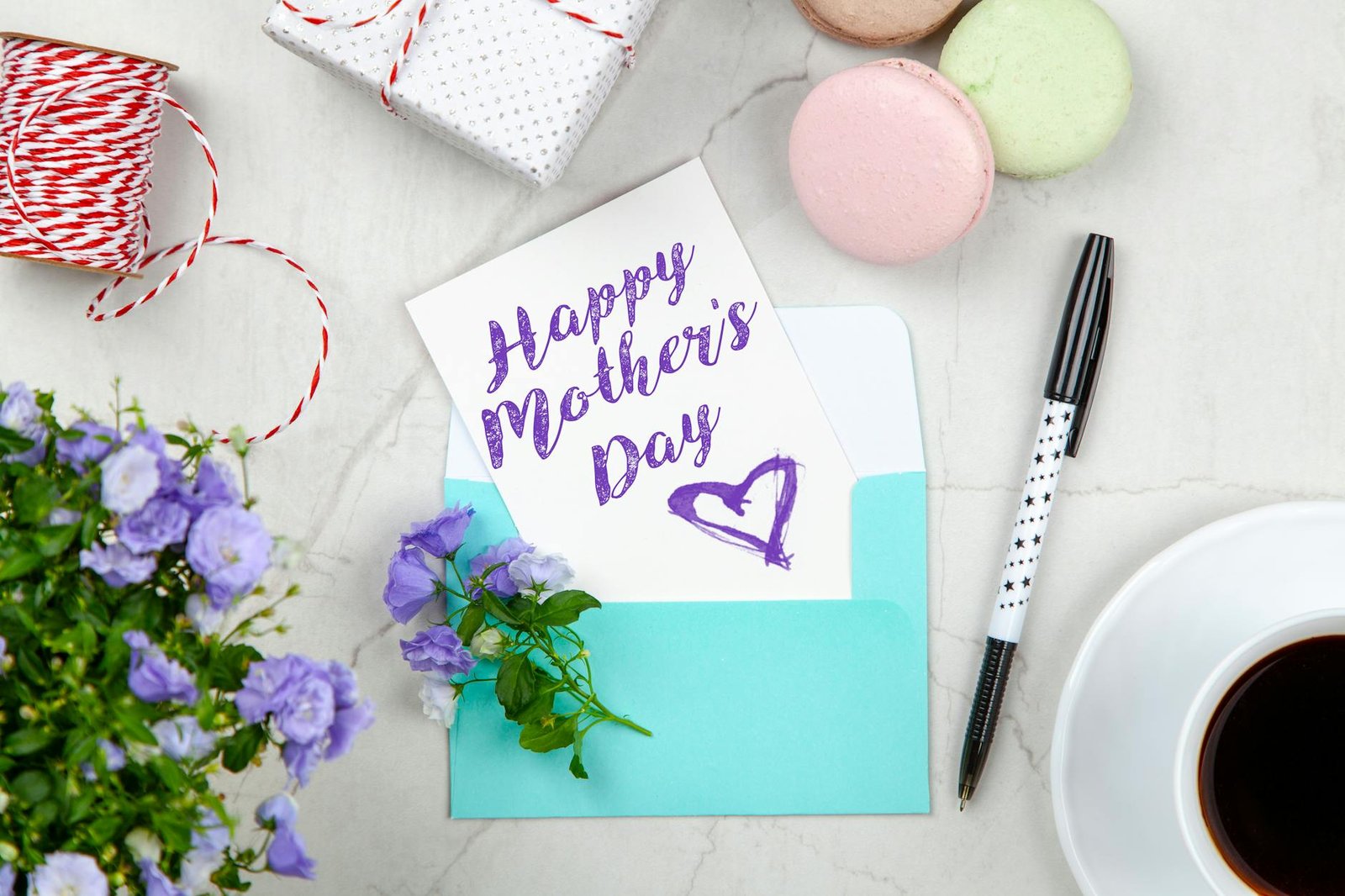 https://www.pexels.com/photo/happy-mothers-day-card-beside-pen-macaroons-flowers-and-box-near-coffee-cup-with-saucer-2072160/